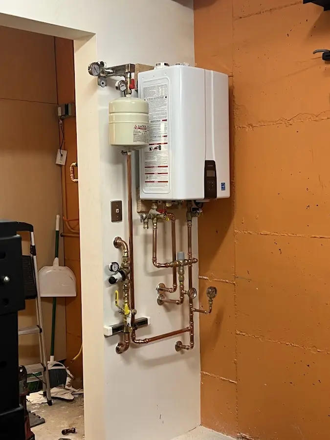Plumbing technician inspecting water heater connections in Vine Hill